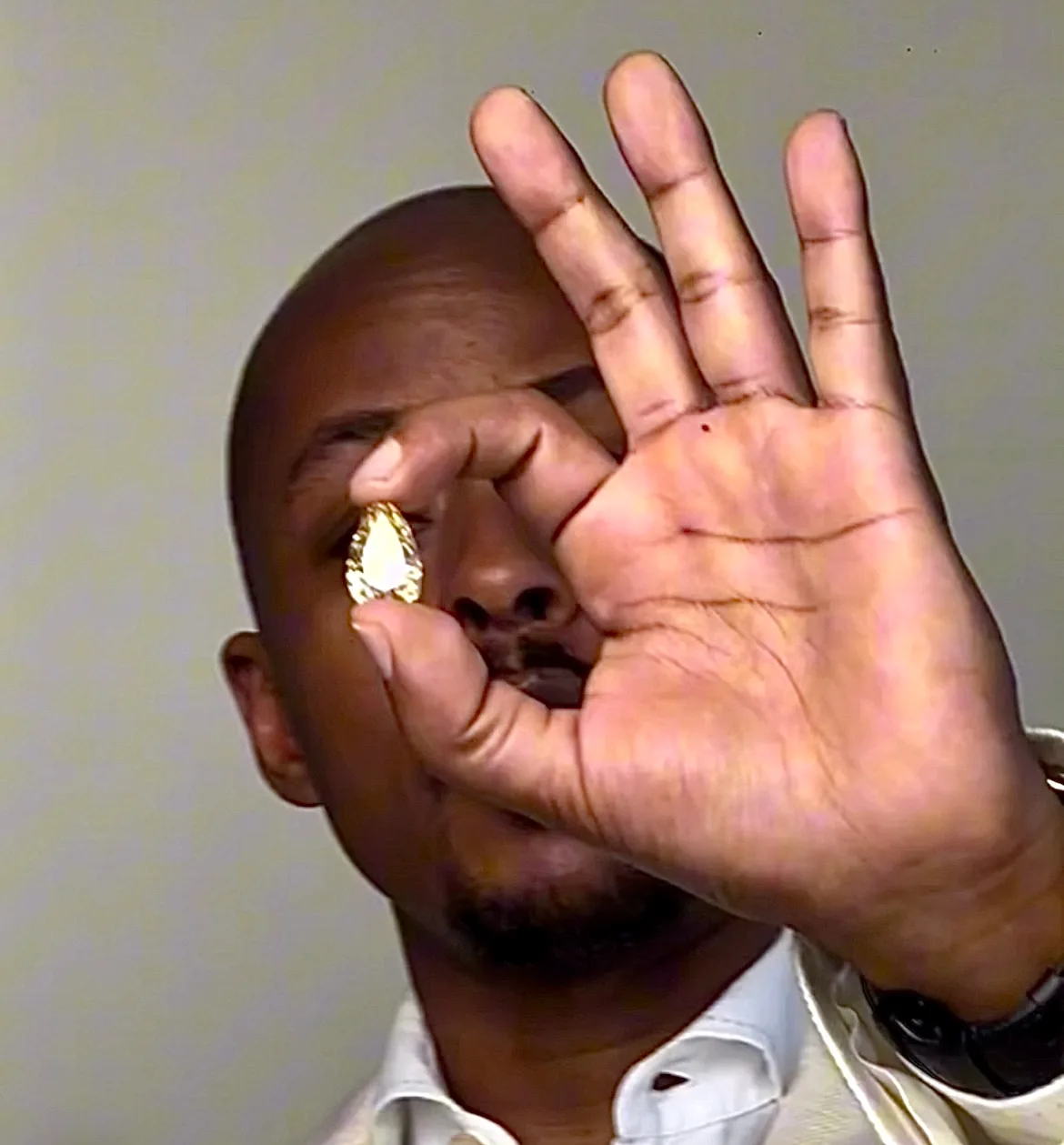 Faiz Fikak examining a pear-shaped stone